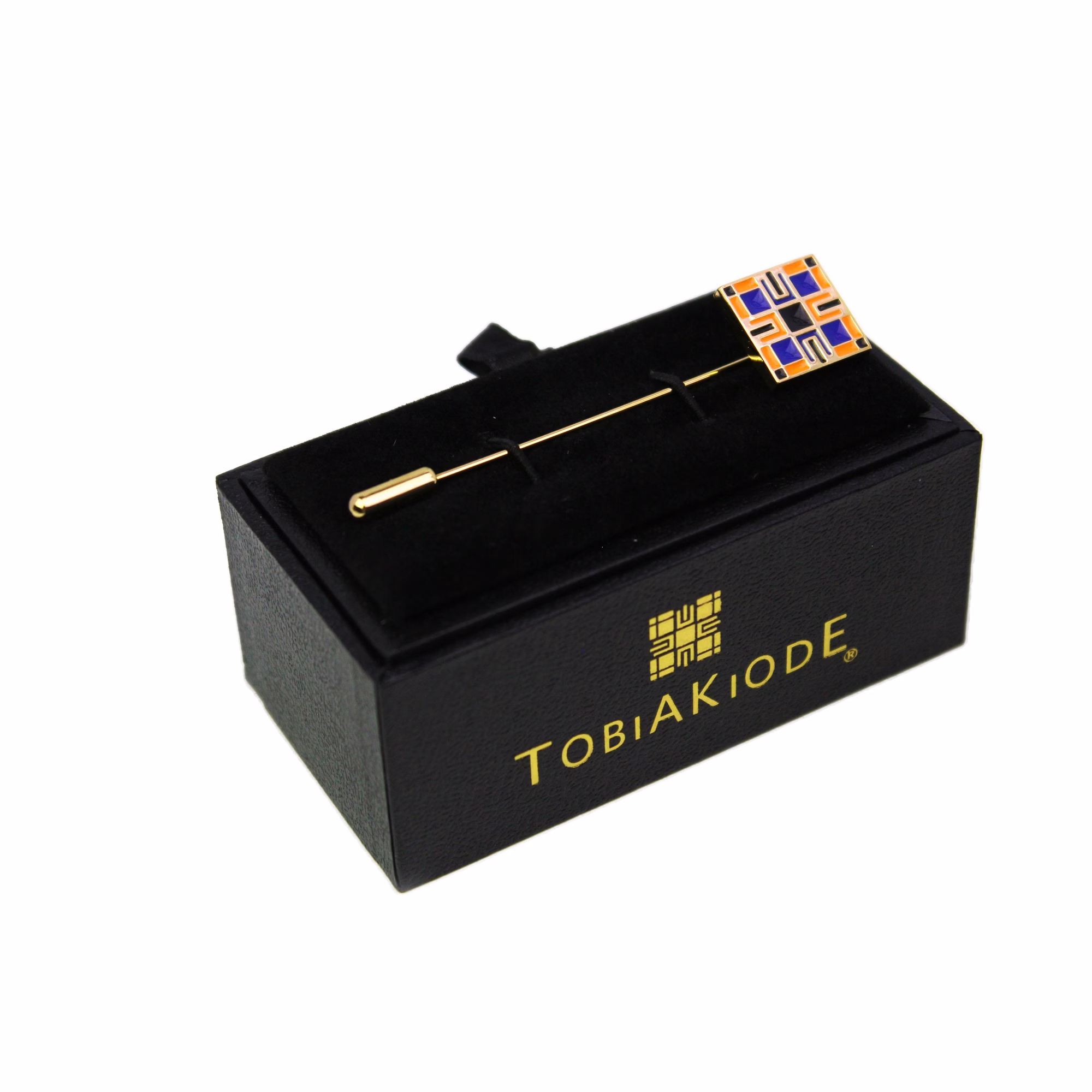 TobiAkiode lapel pin in gold tone with the black-corner geometric logo, boxed angled view